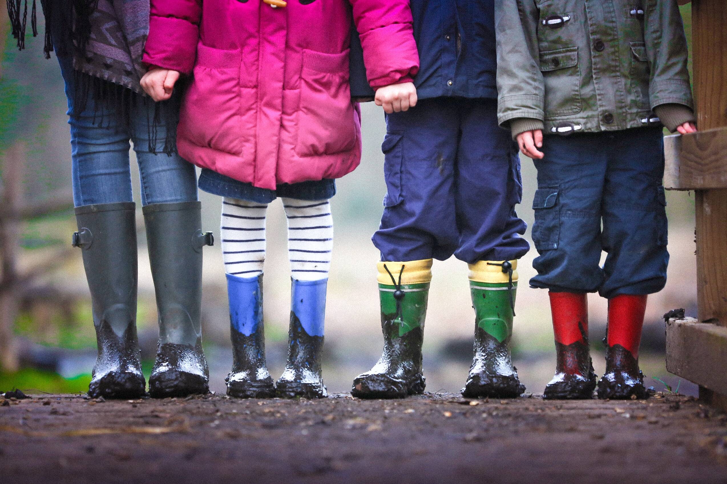 Playing in mud and streams is the best thing. Kinder mit Gummistiefeln im Regen.